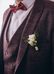 Boutonniere with a rose on the background of the groom's jacket.