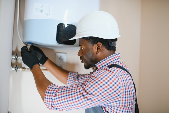 Professional engineer installing a natural gas boiler at home, he is checking the pipes