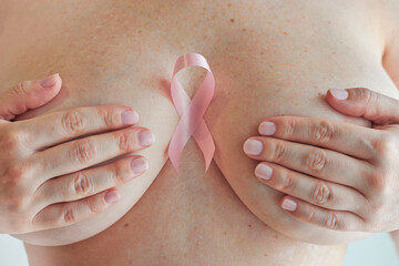 Pink ribbon, a breast cancer symbol, over woman chest