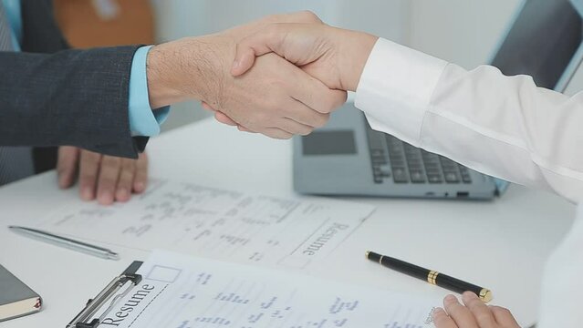 Hands of recruiter holding resume in front of candidate at desk