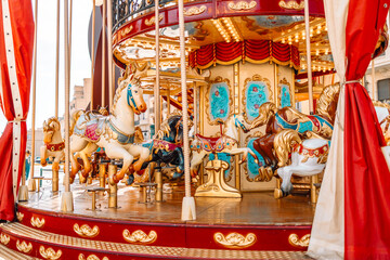 Old French carousel in a holiday park. Three horses and airplane on a traditional fairground vintage carousel. Merry-go-round with horses 