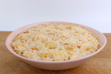 Rice porridge with apples in a bowl close-up.