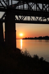 Fototapeta na wymiar Bridge silhouette on background of sunset. Cityscape with sunset.