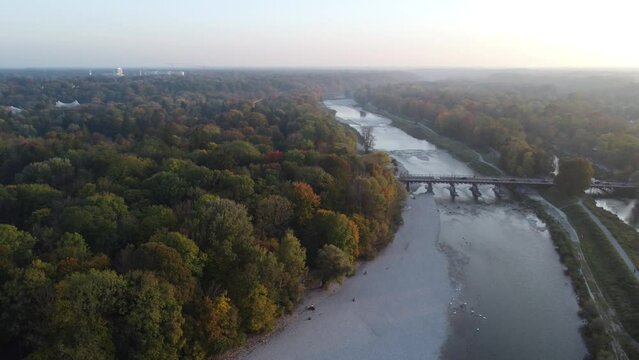 Drone image of isar river flowing into Munich, in beautiful autumn time with colorful trees seen from above