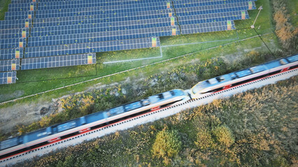Aerial view of solar panels generating electricity connect to train power lines. Clean, green,...