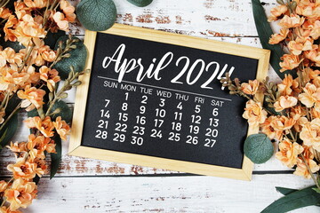 April 2024 monthly calendar with flower bouquet decoration  on wooden background