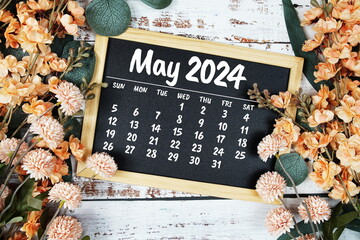 May 2024 monthly calendar with flower bouquet decoration  on wooden background