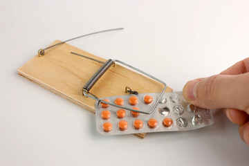 A person sets a trap in a mousetrap in the form of medicine. The concept of drug addiction.
