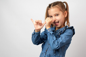 Portrait of little girl teasing someone show finger nose pipe gesture