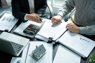 Businesswoman embraces client after successful property negotiation.