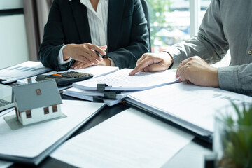 Businesswoman embraces client after successful property negotiation.