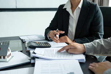 Businesswoman embraces client after successful property negotiation.