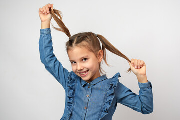 Portrait of cute girl touching ponytail hairs