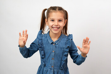 Portrait of cute little smiling girl with raised hands,