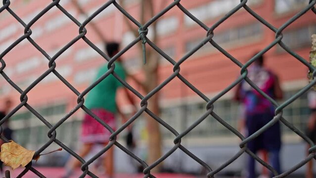 Three-point shot. A basketball player throws the ball into the basket. Multiethnic Guys playing basketball on the street of Paris, Autumn day, blurred background, beautiful bokeh, slow motion.