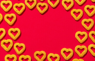 Small heart-shaped cookies on a red background.