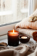 warm cozy window arrangement, winter or autumn concept, candles throw lights