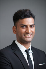 Portrait of cheerful entrepreneur in suit looking at camera