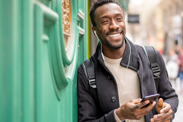 Black-skinned man using mobile phone in the city