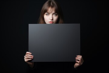 Naklejka premium Young woman holding a blank sign, excited woman holding empty blank board for black friday advertising and markting banner, poster