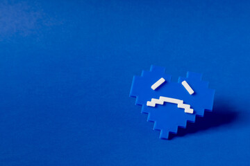 Blue monday concept, which represents the saddest day of the year. Made with a small blue heart with a sad face.