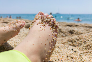 Childs feet covered in thick sand after bathing