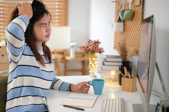 Image of an Asian woman who is tired and overthinking from working with a tablet at the office