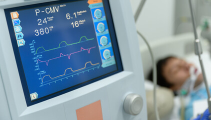 Attached medical equipment such as blood pressure cuff, temperature probe and heart rate monitor with blurry severe patient in intensive care unit (ICU). - obrazy, fototapety, plakaty