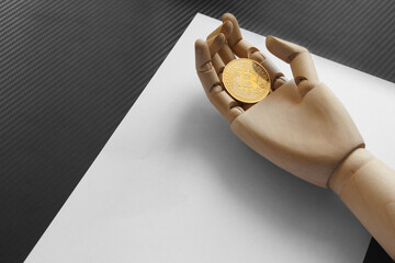 Artificial hand holding one bitcoin on white paper background. Virtual money concept and Financial growth concept. Trading Mining of bitcoins.