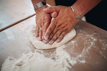 Mani di un pizzaiolo napoletano che stendono la pasta della pizza 