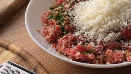 Raw Ground Meat with Herbs and Grated Cheese for making Meatballs. Close-up shot with shallow dof.