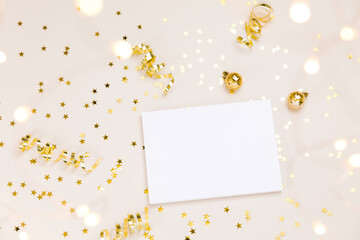 Festive gold background. Empty paper blank, shining stars confetti and fairy lights on beige and Set Sail Shampagne background. Christmas. Wedding. Birthday. Flat lay, top view, copy space