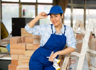 Portrait of contented female foreman of construction team inside a cottage under renovation