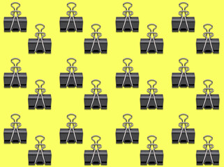 Seamless background pattern of Bulldog Clips on yellow