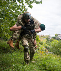 The commander carries a wounded soldier