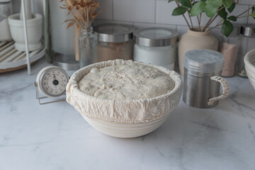 The proofing of sourdough bread is made in the Benetton basket. Home baking.