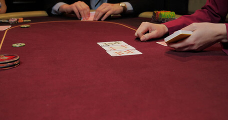 Playing cards in a casino with a man in the background, close-up