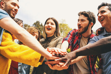 Group of friends with hands together in a show of unity and teamwork, celebrating community and...