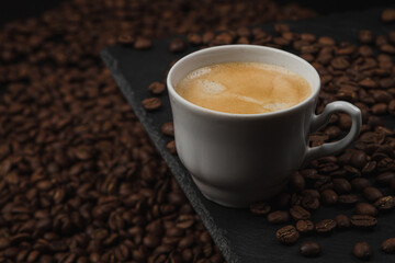 Cup of espresso coffee on a background of coffee beans