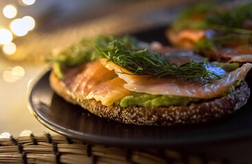 Rye bread sandwich with salmon and avocado. Close up. Photo