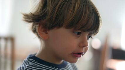 Child chewing food with open wide mouth, close-up face of little boy eating chewy food, mastication...