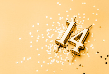 14 years celebration festive background made with golden candle in the form of number Fourteen lying on sparkles. Universal holiday banner with copy space. - obrazy, fototapety, plakaty