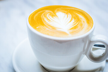latte art with milk foam and milk and espresso in a white porcelain cup