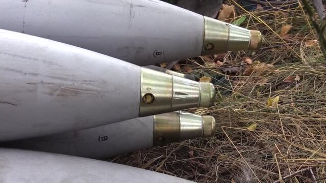 A lot of shells for tanks in cannons lie on dry grass. Preparation for battle. A real war. Russian-Ukrainian war.