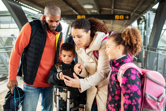 African American Family Using Smartphone at Train Station