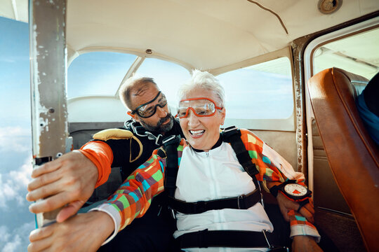 Smiling Senior Woman and Instructor in Airplane Before Skydiving