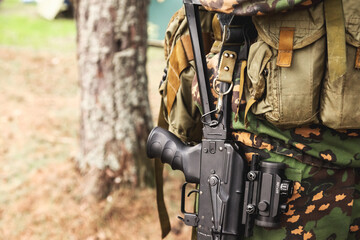 Close up weapon russian soldier man in military camouflage uniform with weapon in forest day at...