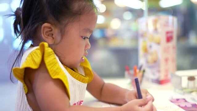 Adorable elementary school girl drawing color paint on paper imagination of childhood education concept