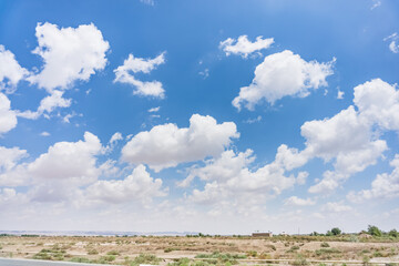 Cloudy blue sky with cumulus clouds in the desert in hot summer