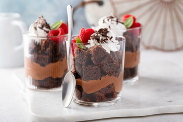 Chocolate mousse and brownie parfait layered in a cup with raspberries